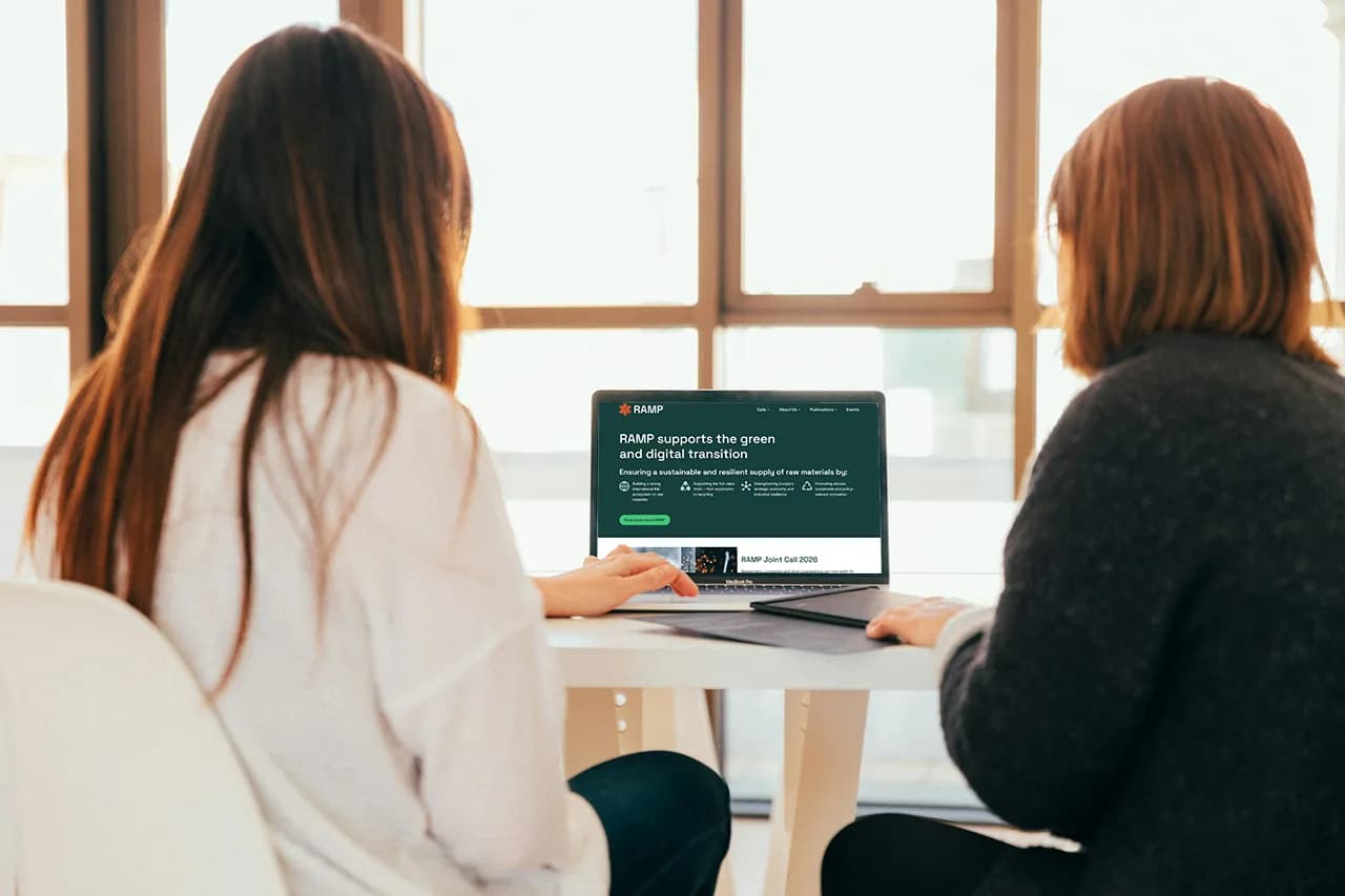 Two women sitting in front of a laptop