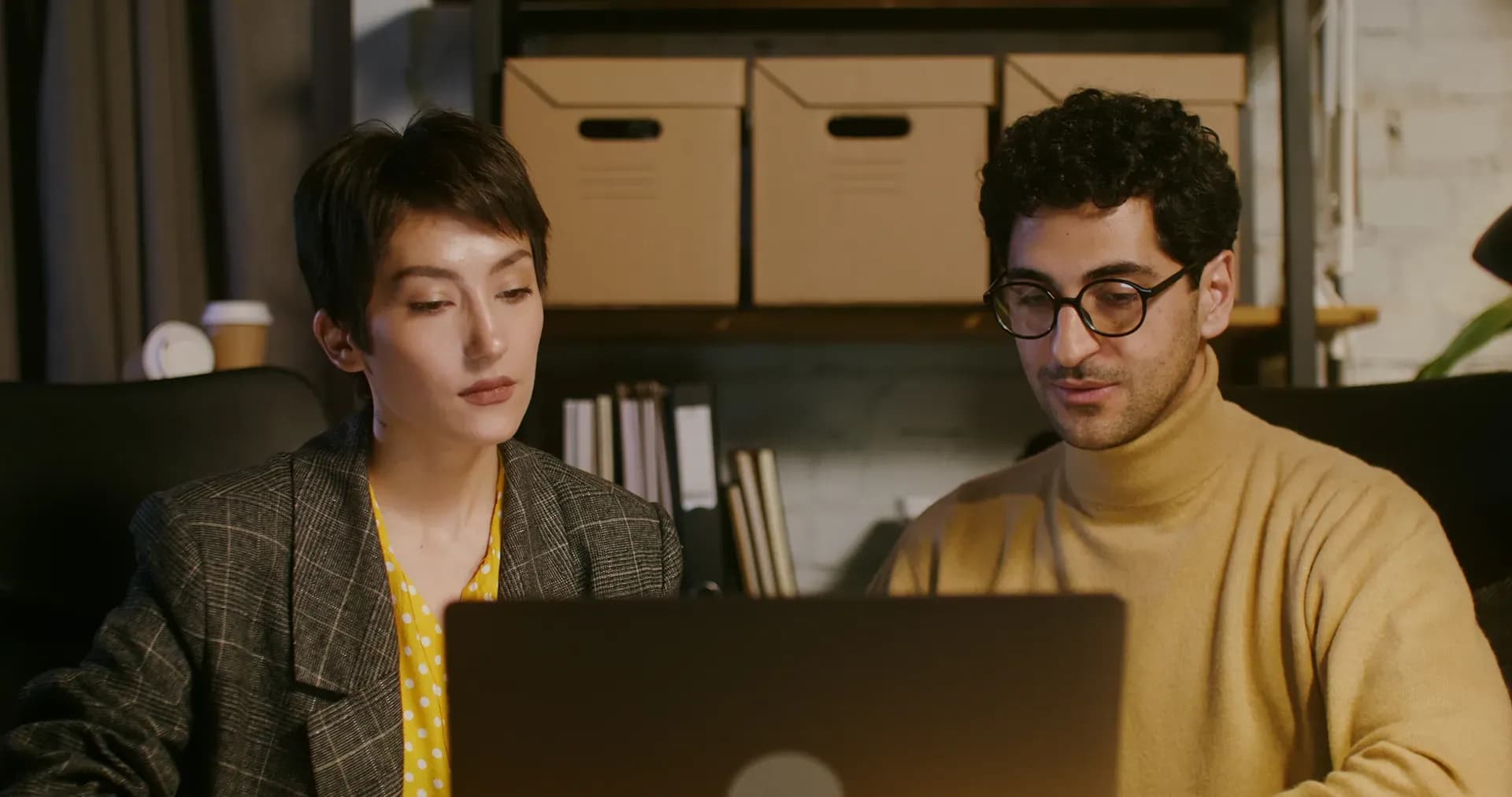 Woman and man sitting in front of a laptop